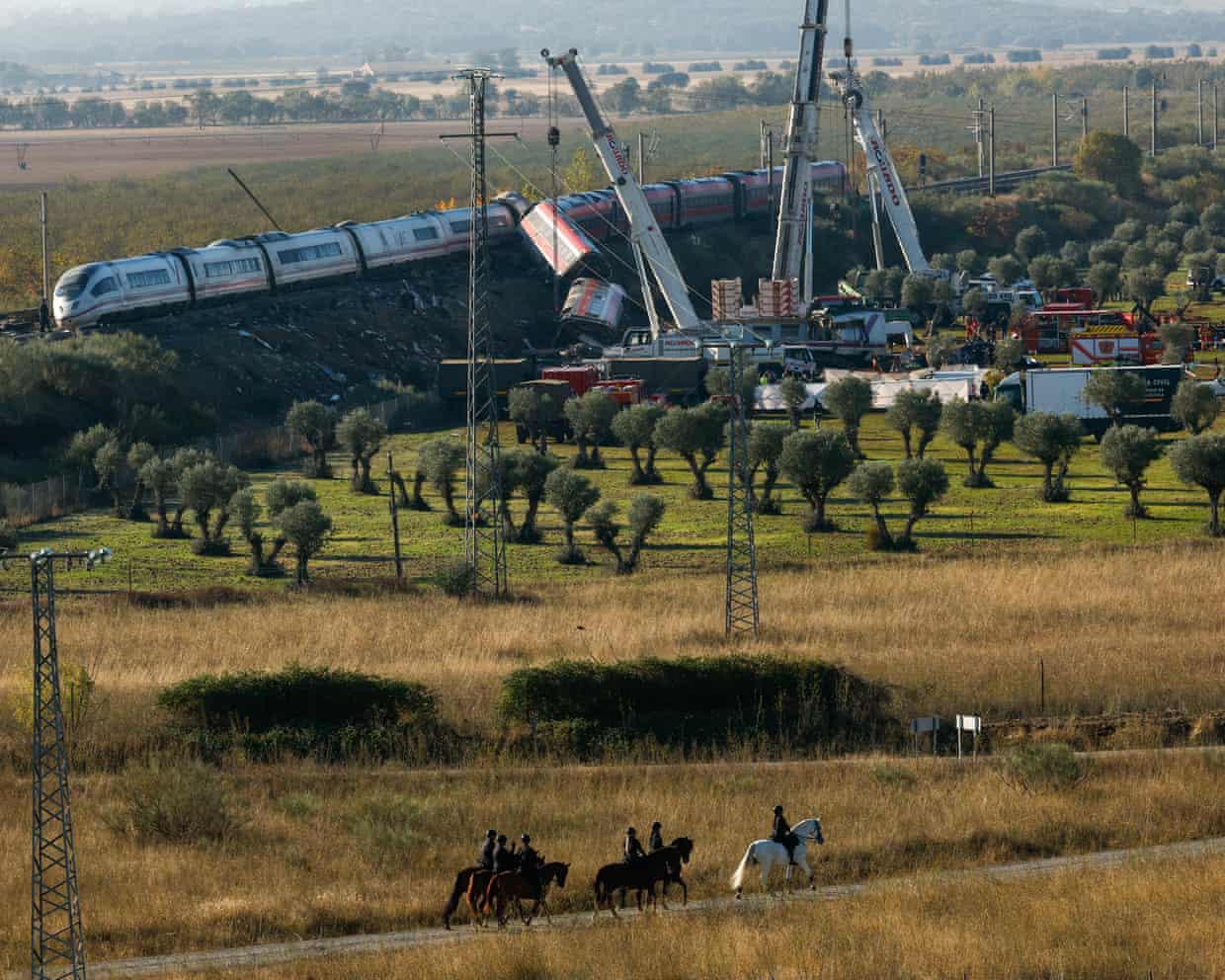 A crane at the scene of a train crash. One of the pictured train's carriages has left the tracks.