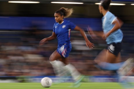 कैटरिना मैकारियो, नीली किट पहने हुए, चेल्सी महिलाओं के लिए गेंद लेकर दौड़ती हैं