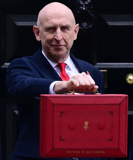 John Healey holds up the red box in Downing Street before going to the Commons for his budget