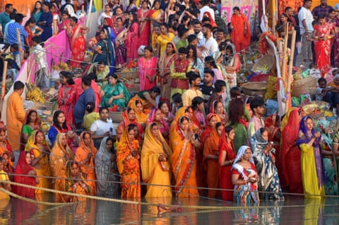 People wearing brightly coloured clothes, some of them standing in the water