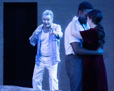 Man stands behind and points to couple embracing