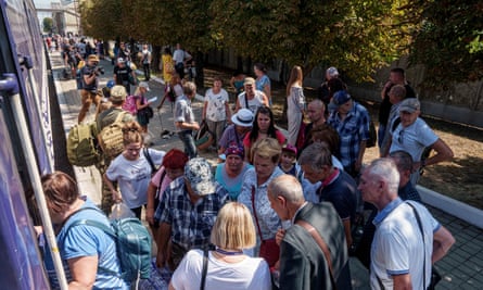 People queue to board an evacuation train in Pokrovsk, in the Donetsk region of Ukraine, Monday 19 August 2024.