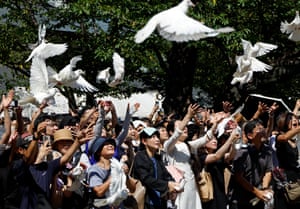 White doves are released into the air above a crowd of people