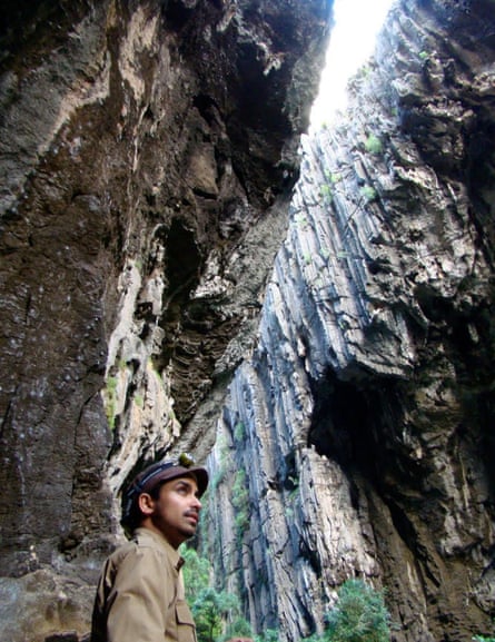Prosanta Chakrabarty, who specialises in cavefish, in a cave with the light entering from high above him.