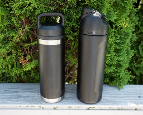 two black reusable water bottles next to each other outside