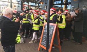 Jim Sheridan films Ian Bailey with Christmas carol singers in Dublin