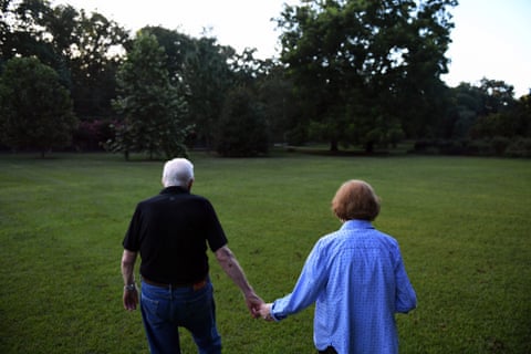 Jimmy Carter walks with his wife, Rosalynn Carter, toward their home.