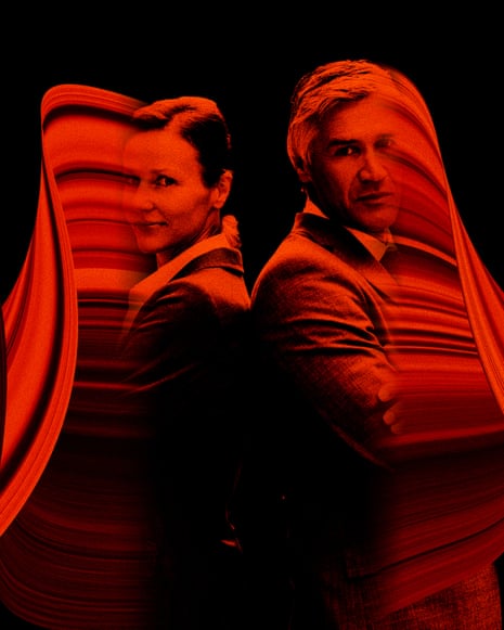 A man and a woman stand back to back with arms crossed. A red light swirls around them.