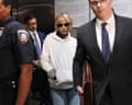 A woman in a white hoody and sunglasses surrounded by people.