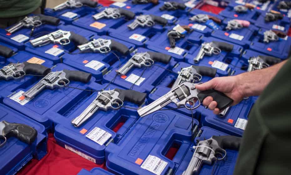 People look at handguns as thousands of customers and hundreds of dealers sell, show, and buy guns and other items during The Nation’s Gun Show at the Dulles Expo Center which is the first major gun show in the area since the Oregon shooting in Chantilly, VA on Saturday, October 03, 2015. (Photo by Jabin Botsford/The Washington Post via Getty Images)