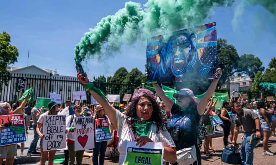 A group of abortion rights activists hold up signs outside the White House in Washington DC on 4 July