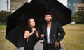 Angus and Julia Stone walk with umbrellas in the Domain in Sydney, Australia
