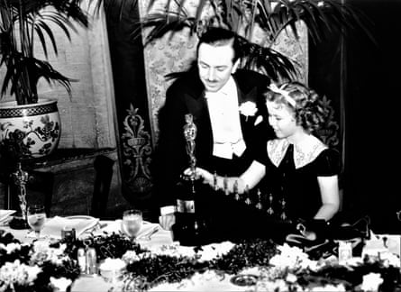 Shirley Temple présente à Walt Disney son prix spécial Oscar pour Blanche-Neige, comprenant sept mini statuettes, en février 1939.