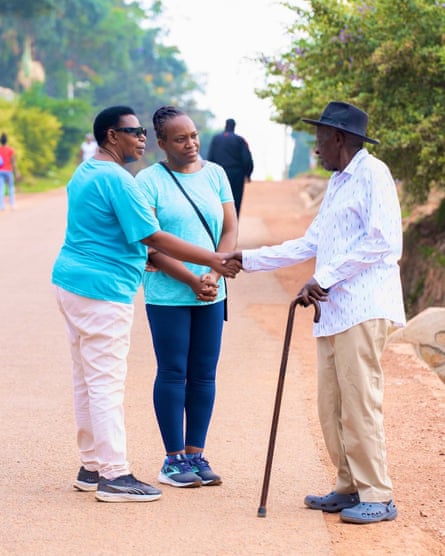 Two women talk to an older man who is shaking hands with one of them