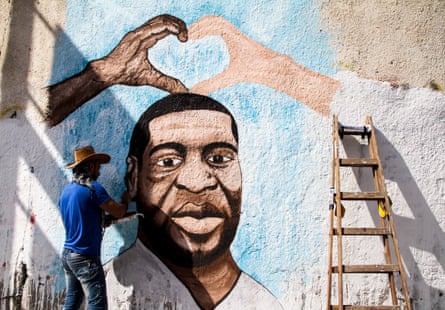 The Palestinian artist Ayman al-Hasari paints a mural of George Floyd on a wall in Gaza City.