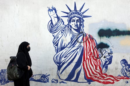 A woman walks past an anti-US mural in Tehran showing a broken-up Statue of Liberty.
