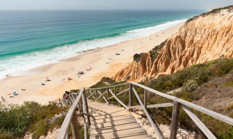 Wooden staircase in the sandstone cliffs giving access to Gale beach, Comporta, Portugal