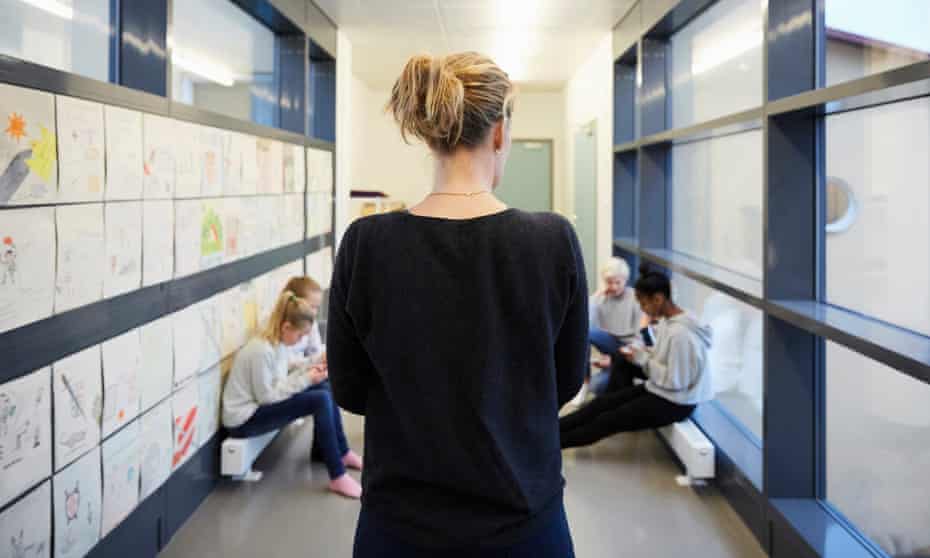 Teacher and pupils in a school corridor
