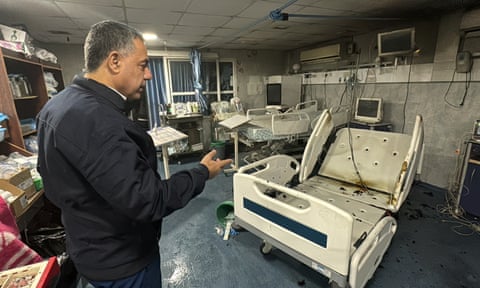 Abu Safiya pointing to a damaged hospital bed