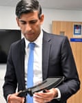 Britain's Prime Minister Rishi Sunak holds a machete seized from knife attacks during a visit to the Kilburn police station, northwest of London.