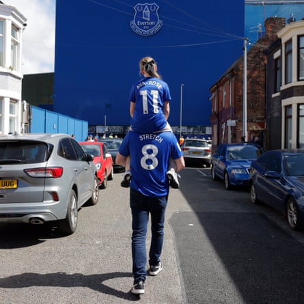 A father and daughter walk down a street to Goodison Park