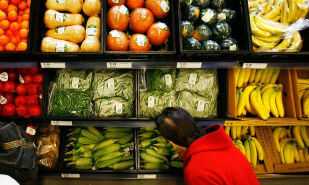 A shopper selects from pre-packaged produce