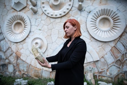 Marina Mimoza, a local artist and the director of the Rezon street art festival in Mostar, holds one of the broken memorial stones