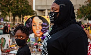 A mother and son attend a demonstration in downtown Louisville, close to the makeshift memorial for Breonna Taylor.