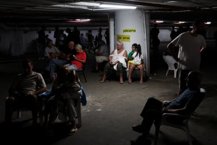 People sit in an underground shelter