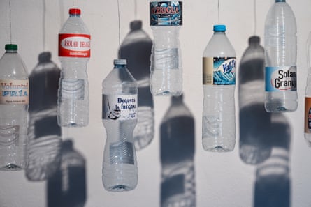 Plastic water bottles hanging, with their shadows behind them, in an artwork created by artist Fidel Martinez, called El Agua Secuestrada, in Gualba, Catalonia, where the river and reservoir ran dry in 2023