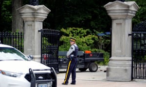 A police officer stands near a damaged gate at Rideau Hall, where Justin Trudeau lives.