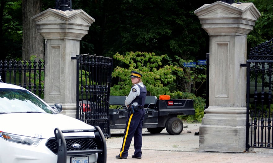 A police officer stands near a damaged gate at Rideau Hall, where Justin Trudeau lives.