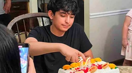 A young man cuts a cake.
