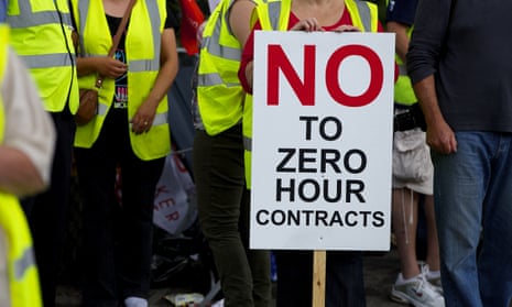 A protest in Wigan, with one demonstrator hiolding a,loft a placard declaring 'No to zero-hours contracts.'