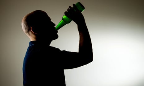 A man downing a bottle of beer