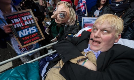 A Boris Johnson impersonator lies in a makeshift hospital bed next to an effigy of Theresa May during a demonstration in London on Saturday.