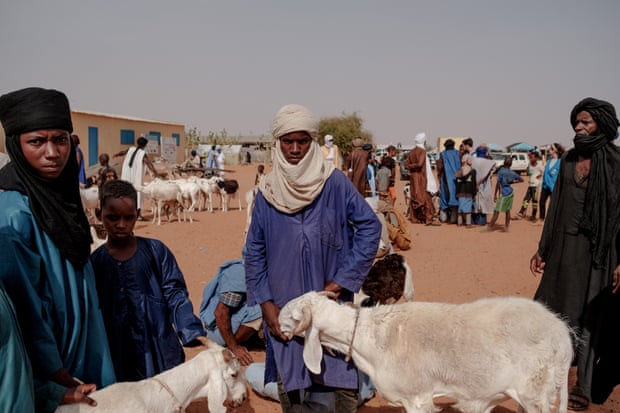 Men walk around the weekly sheep market in M’bera refugee camp