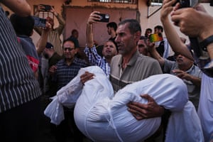 A man carries a shrouded body