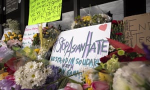Flowers, candles and signs are arranged in a memorial outside Young’s Asian Massage