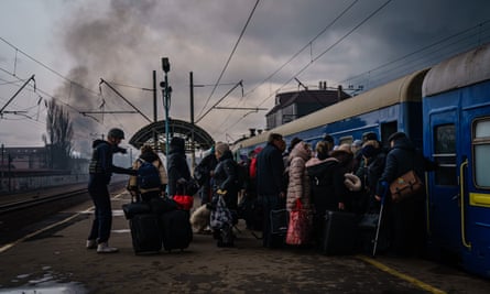 Civilians, mostly women and children rush to board any train car that still has any room on it, in Irpin, Ukraine, on Friday.