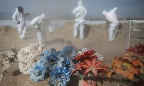 Cemetery workers in personal protective equipment shovel dirt as they bury a victim of Covid-19 at Sueños Eternos cemetery in Ciudad Juarez, Mexico.