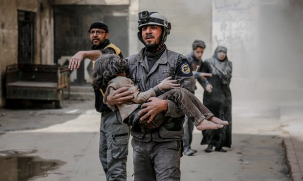A rescue worker carries a girl who was found alive inside the debris of buildings in eastern Ghouta.