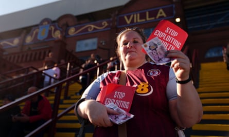 An Aston Villa fan handing out leaflets and fake bank notes for a protest ahead against ticket pricing in their first Champions League campaign.
