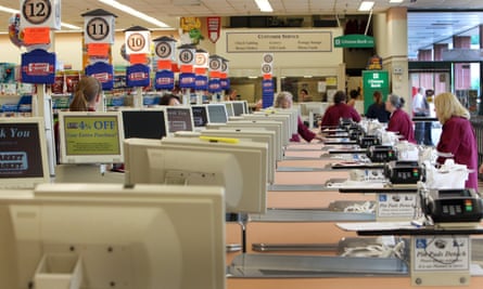 Cashiers and baggers sit idle at the Market Basket supermarket chain in Concord, N.H.