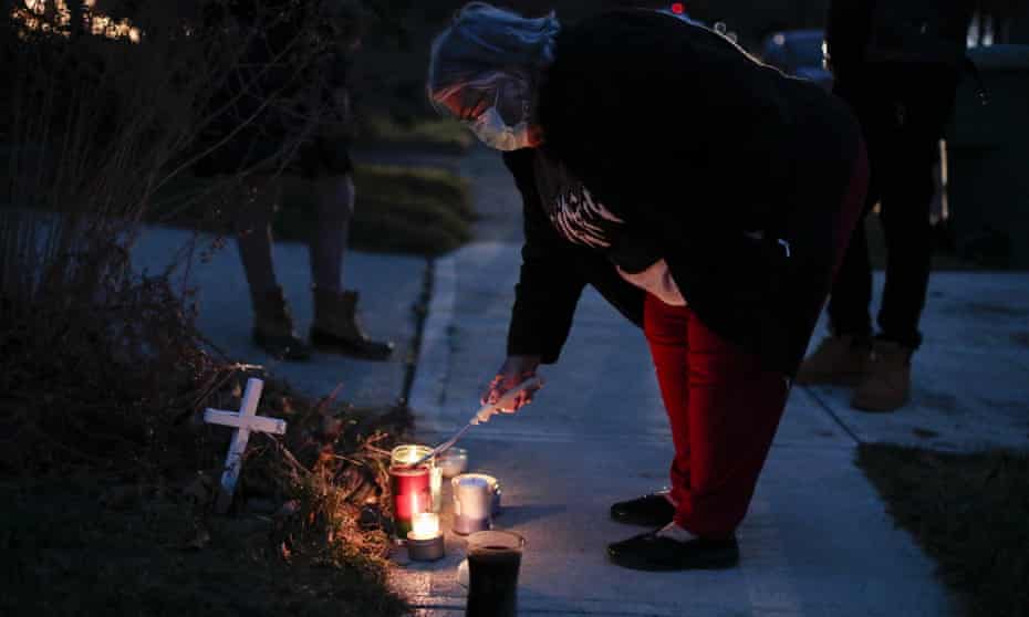 A neighbor lights a candle at a small memorial near the site of the fatal police shooting of Andre Hill by police in Columbus, Ohio. 