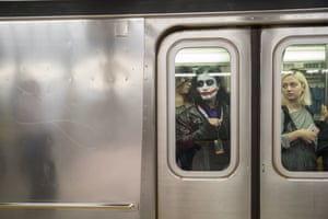 A Comic-Con fan dressed as the Joker rides the 7 train on the way to the event