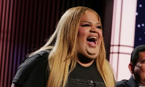 A woman smiles on a live television set