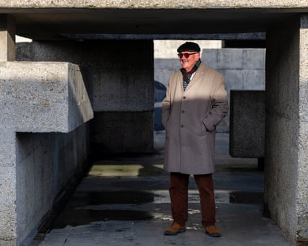 man stands in sunshine falling through modernist architecture