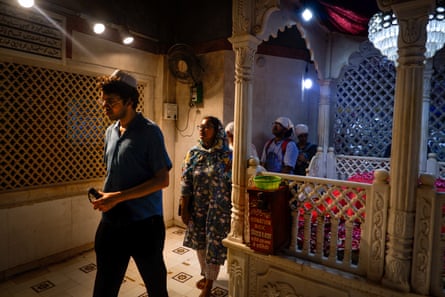 A group walks past a marble tomb