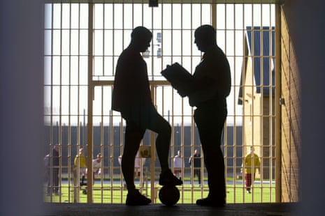 A custody officer speaks to a young offender before a football match at a youth prison